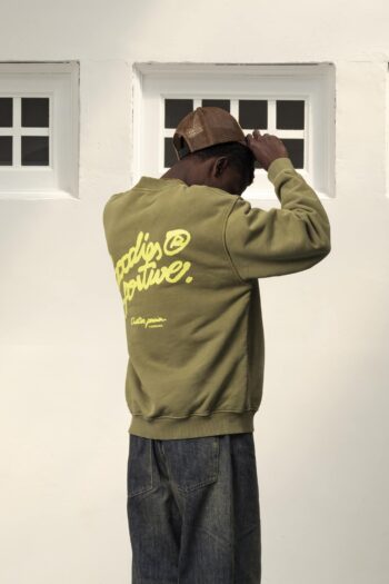 A model with The Pegasus Khaki Crewneck by Goodies Sportive